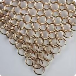 Gold-coloured woven aluminium ring mesh laid flat