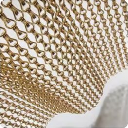 Gold bronze aluminium woven ring mesh draped over a surface