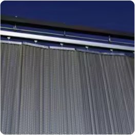 A hanging spiral wire decorative mesh curtain across a window