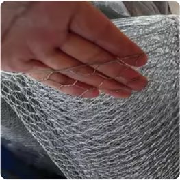 A hand lifting a roll of fine galvanized hexagonal netting