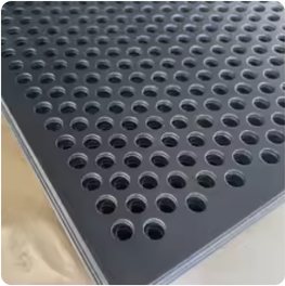 A stack of dark PVDF-coated perforated metal sheets with round holes