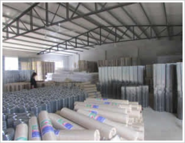 Rolls and panels of finished welded mesh stacked in the steel-framed warehouse